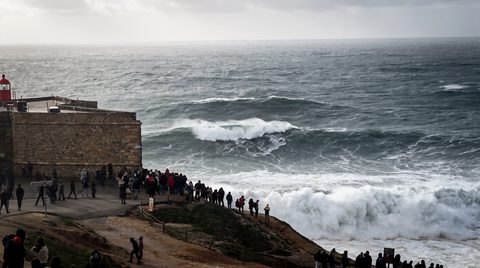 A set of large, glassy offshore swell lines approaching the Nazaré coastline