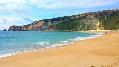 Nazaré town beach beneath the cliffs of Sítio, with the clifftop village visible above
