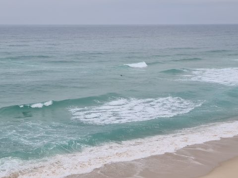 Waves breaking off the long sandy beach at Rei Cortiço, seen from above