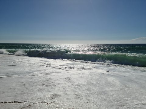 Waves breaking along the sand at Praia do Salgado